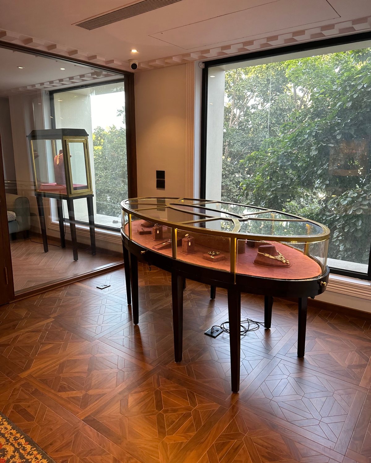 Oval brass and glass vitrine by the window
